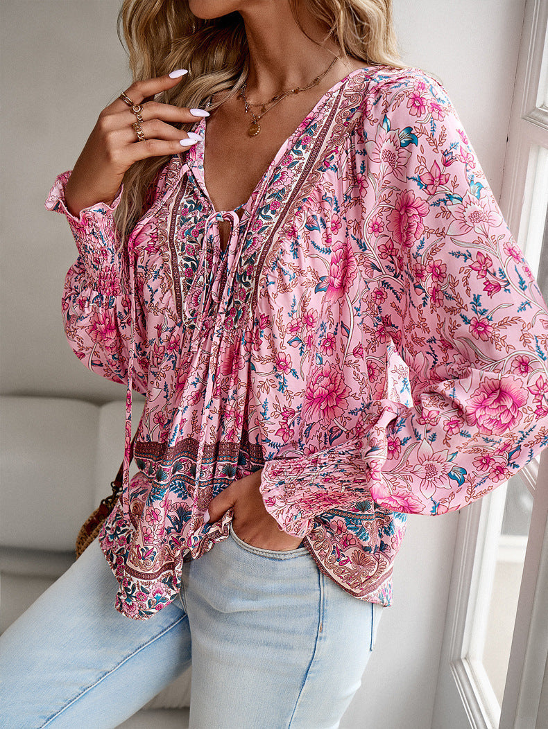 Femme portant une blouse fluide imprimée rose à col V et manches longues – modèle féminin et élégant disponible chez Luxorel