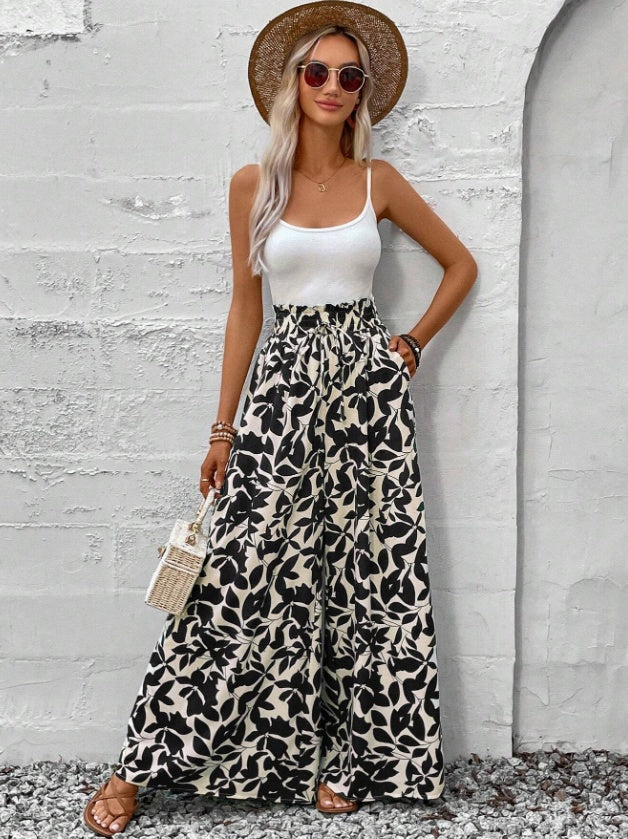 Femme portant un pantalon large à motifs floraux noir et blanc, coupe fluide et taille haute – style bohème chic signé Luxorel