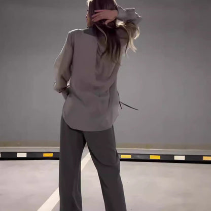 Femme portant un ensemble composé d’un pantalon fluide et d’une chemise oversize assortie, style minimaliste chic – disponible en beige et gris chez Luxorel

