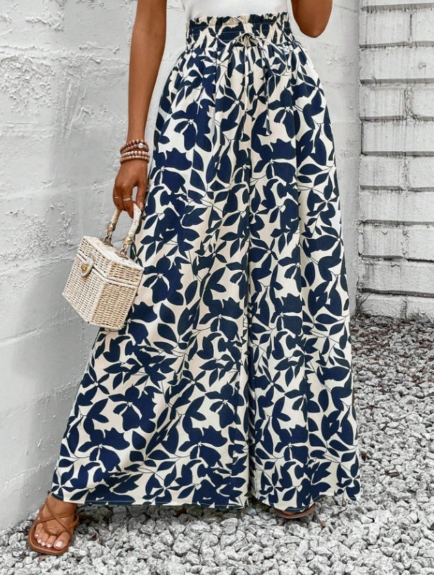 Femme portant un pantalon large à motifs floraux noir et blanc, coupe fluide et taille haute – style bohème chic signé Luxorel