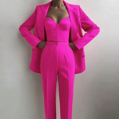 Femme portant un ensemble fuchsia 3 pièces composé d’un blazer oversize, d’un gilet et d’un pantalon droit – tenue stylée et moderne disponible chez Luxorel