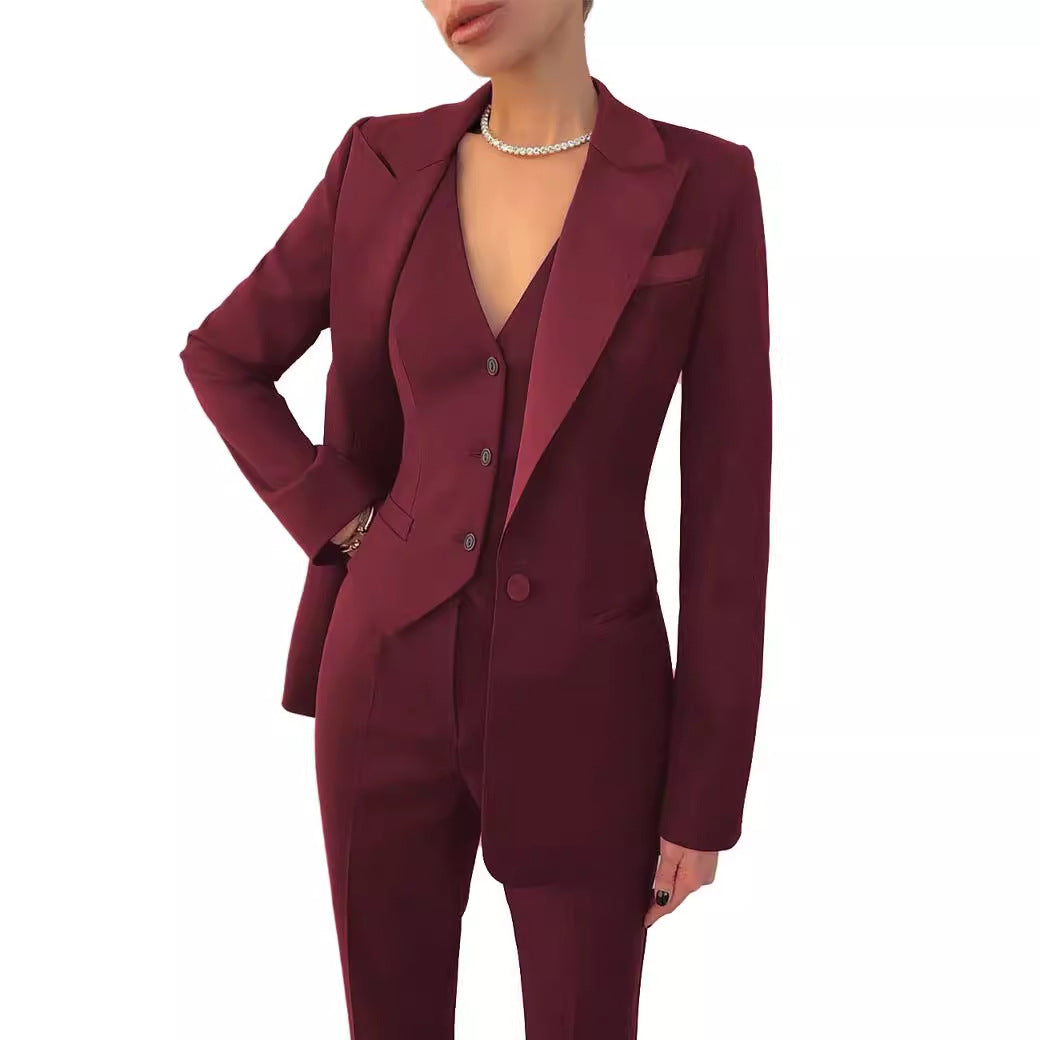 Femme portant un ensemble tailleur bordeaux 3 pièces composé d’un blazer, d’un gilet et d’un pantalon ajusté – tenue professionnelle chic signée Luxorel