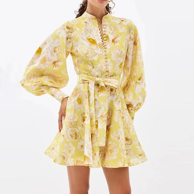 Femme portant une robe courte évasée jaune à fleurs, avec ceinture à nouer – style décontracté et estival proposé par Luxorel