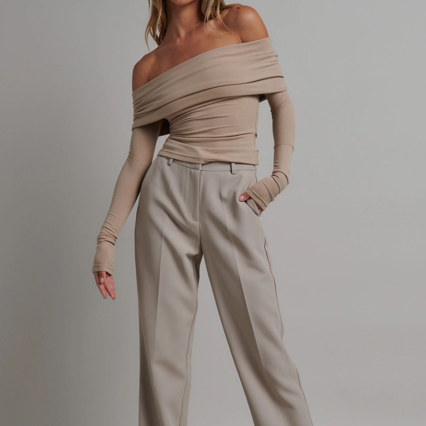 Femme portant un haut moulant à col bardot drapé et manches longues, disponible en noir et beige – modèle chic et féminin proposé par Luxorel

