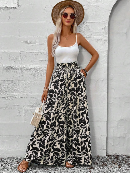 Femme portant un pantalon large à motifs floraux noir et blanc, coupe fluide et taille haute – style bohème chic signé Luxorel